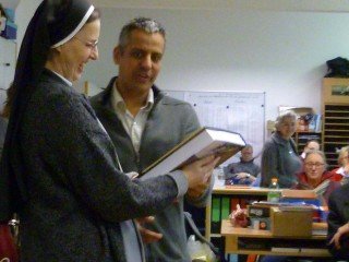 Schulleiterin Sr. Maria Thoma Dikow bedankt sich für das Buch über das St. Peter's College, das ihr Daniel Ganama bei der Begrüßung im Lehrerzimmer überreichte. (Foto: SMMP/Hentrich)