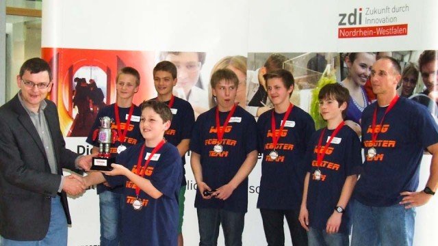 Erster Platz und Pokal für das Walburgisgymnasium: Roboterteam Attraktivundpreiswert_Junior1 mit Herrn Peters (re.) bei der Siegerehrung am 14. Juni 2013 in Meschede. (Foto: WBG/Peters)